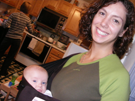 Kim looking foxy with a baby in a sling